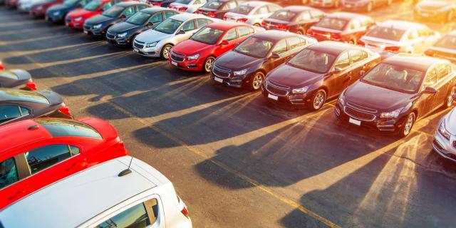 Estacionamento com uma série de carros estacionados com o sol ao fundo