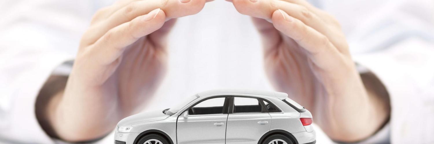 Close em mão masculina cobrindo uma miniatura de carro