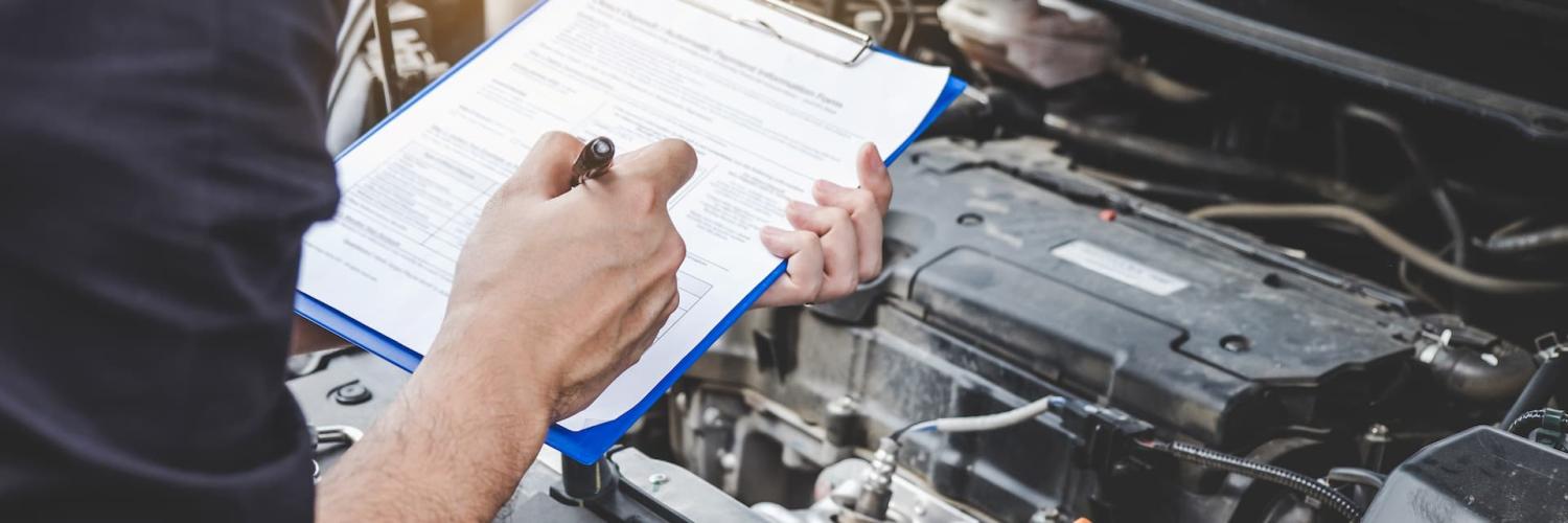 Reparador de mecânico de automóveis verificação de motor de carro com inspeção escrevendo na área de transferência a lista de verificação de máquina de reparo, serviço e manutenção de automóveis